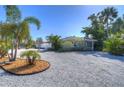 Inviting home exterior with a gravel driveway, mature palm trees, and well-maintained landscaping at 5240 31St S Ave, Gulfport, FL 33707