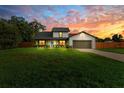 Attractive home exterior with a well-kept lawn and a beautiful sunset backdrop, perfect for evening relaxation at 5303 Glen Harwell Rd, Plant City, FL 33566