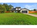 Charming two-story home featuring a well-manicured lawn, mature landscaping, and neutral color palette at 5303 Glen Harwell Rd, Plant City, FL 33566
