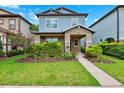Charming two-story home showcasing a covered porch, manicured lawn, and vibrant landscaping at 5831 Caldera Ridge Dr, Lithia, FL 33547