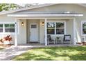 Close-up of covered front porch with seating area and freshly painted exterior at 615 6Th N Ave, Safety Harbor, FL 34695