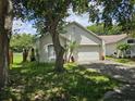 Single story home featuring a 2 car garage, complemented by mature landscaping and tree-shaded lawn at 6203 Calamari Pl, Riverview, FL 33578