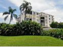 An exterior view of the condo building with balconies and lush tropical vegetation surrounding the property at 6218 Palma Del Mar S Blvd # 503, St Petersburg, FL 33715