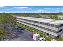 Exterior view of the condo building showcasing well-maintained landscaping and ample parking at 8100 Dr Martin Luther King Jr N St # 202, St Petersburg, FL 33702