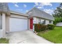 The exterior features a red front door, attached garage, and manicured landscaping at 8447 Orleans N, Pinellas Park, FL 33781