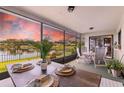Inviting screened-in lanai featuring a dining table with peaceful waterfront views at 8515 Macoma Ne Dr, St Petersburg, FL 33702