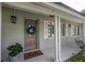 Close-up of the front door with a decorative wreath, a 'hello' doormat, and a potted flower arrangement at 8701 Driftwood Drive Dr, Tampa, FL 33615