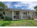 Inviting front porch with detailed wooden door and manicured landscaping, creating an appealing entrance at 8701 Driftwood Drive Dr, Tampa, FL 33615