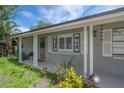 Charming front porch featuring classic columns, shuttered windows, and a welcoming entryway at 8701 Driftwood Drive Dr, Tampa, FL 33615