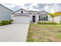 Charming single-story home showcasing a well-manicured lawn, neutral paint scheme, and attached two-car garage at 9098 Forge Breeze Loop, Wesley Chapel, FL 33545