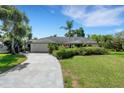 Single-story home with lush green lawn and established landscaping, offering a serene and inviting curb appeal at 1000 Chatham Ct, Safety Harbor, FL 34695