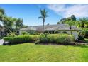 Well-maintained home with vibrant green lawn and mature hedges providing privacy and curb appeal at 1000 Chatham Ct, Safety Harbor, FL 34695