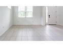 Bright living room with modern tile flooring and a large window allowing natural light to flood the space at 11035 Sage Canyon Dr, Riverview, FL 33578