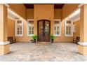 Elegant front entrance of a custom home with a double door entry, brick flooring, and mature landscaping at 11430 Trotting Down Dr, Odessa, FL 33556