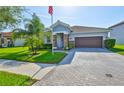 This inviting home features a two-car garage, manicured lawn, mature palm trees and classic stucco siding at 13113 Green Violet Dr, Riverview, FL 33579