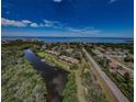 An aerial view of a waterfront community with a bay view, lush landscaping, and a swimming pool at 1729 Seascape Cir # 102, Tarpon Springs, FL 34689