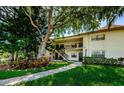 Inviting condo exterior with lush landscaping, walkway and a view of the two-story building at 1729 Seascape Cir # 102, Tarpon Springs, FL 34689