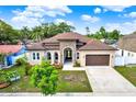 Inviting single-story home with a stone accent facade, arched entryway, and a lush front yard at 17838 Morninghigh Dr, Lutz, FL 33549