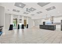 Open-concept living space features large tile flooring, recessed lighting, and seamless flow to the kitchen at 17838 Morninghigh Dr, Lutz, FL 33549