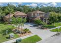 Two-story home with a well-manicured lawn, mature trees and attractive desert landscaping at 18434 Eastwyck Dr, Tampa, FL 33647