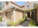 Welcoming townhome entrance with an arched pergola and tan stucco exterior at 18809 Duquesne Dr, Tampa, FL 33647
