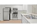 Bright kitchen with stainless steel appliances, white cabinets, and modern hardware at 18809 Duquesne Dr, Tampa, FL 33647