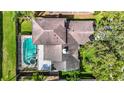 Aerial view of home showcasing roof, screened in pool and spa, and surrounding manicured landscaping at 1906 White Cedar Way, Brandon, FL 33511