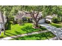 Lovely single-story home featuring a lush lawn, mature tree, and a driveway leading to the garage at 1906 White Cedar Way, Brandon, FL 33511