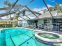 Sparkling pool with attached hot tub inside a screened enclosure and outdoor seating at 1906 White Cedar Way, Brandon, FL 33511