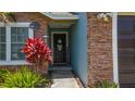 Charming entryway with a wreath-adorned door and vibrant landscaping at 2254 Springrain Dr, Clearwater, FL 33763