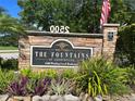 Community sign for The Fountains at Countryside, showcasing stone work, landscaping, and the address at 2500 Winding Creek Blvd # B105, Clearwater, FL 33761