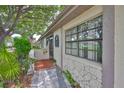Inviting facade with stone accents and a quaint front porch adorned with lush greenery and a welcoming American flag at 2609 Lancaster Dr, Sun City Center, FL 33573