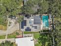 Aerial view of a home featuring solar panels, a refreshing pool, and lush green landscaping at 2718 Boca Ciega N Dr, St Petersburg, FL 33710