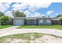 Charming one-story home featuring a quaint front porch, attached garage, and well-maintained lawn at 2809 49Th N St, St Petersburg, FL 33710
