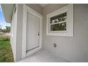 Inviting entryway showcasing a white door and trim, complemented by a nearby window for natural light at 2810 N 75Th St, Tampa, FL 33619