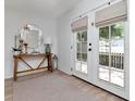 Bright entryway featuring a stylish table, round mirror, and double doors leading to the outside at 2822 W Bay Ave, Tampa, FL 33611