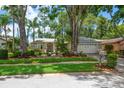 Well-maintained single-story home featuring mature trees, lush landscaping, and a manicured lawn at 3273 Tanglewood Trl, Palm Harbor, FL 34685