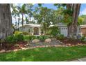 Inviting single-story home with lush landscaping, stone accents, and well-manicured lawn at 3273 Tanglewood Trl, Palm Harbor, FL 34685
