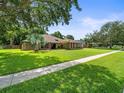 Beautifully landscaped home with mature trees and a well-maintained lawn at 3305 Westmoreland Dr, Tampa, FL 33618