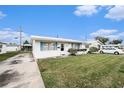 Charming single-story home with a well-manicured lawn and white exterior, complemented by a clean driveway at 4325 93Rd N Ter, Pinellas Park, FL 33782