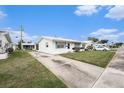 Well-maintained single-story home with a white exterior, features a neatly kept lawn and extended driveway at 4325 93Rd N Ter, Pinellas Park, FL 33782