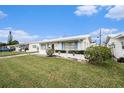 Well-maintained single-story home with a white exterior, features a neatly kept lawn and coastal-themed decor at 4325 93Rd N Ter, Pinellas Park, FL 33782