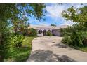 Charming home featuring a well-maintained lawn and circular driveway at 4545 Clearwater Harbor N Dr, Largo, FL 33770