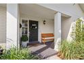 A welcoming front porch offers seating next to a black door with updated hardware at 460 Althea Rd, Belleair, FL 33756