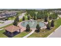 Aerial view showcasing the community's fountain, landscaping, clubhouse, and surrounding residential area at 4653 Ancona Way, Wesley Chapel, FL 33543