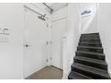 Stairwell features metal stairs with white walls, an entry door, and modern details at 5008 S Macdill Ave # 16, Tampa, FL 33611