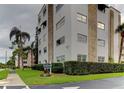 Exterior angle of condo building showing stone detail and lush green landscaping at 5603 80Th N St # 103, St Petersburg, FL 33709