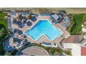 Aerial view of a community pool with tiki umbrellas, lounge chairs, and a hot tub at 5633 Puerta Del Sol S Blvd # 204, St Petersburg, FL 33715