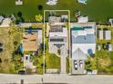 Aerial view of the neighborhood showing a single-Gathering home with manicured lawn, solar panels and docks on the water at 6531 Seaview Blvd, Hudson, FL 34667