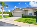 Charming one-story home with a two-car garage, well-manicured lawn, and lush landscaping at 6606 Pullen Ct, Tampa, FL 33625